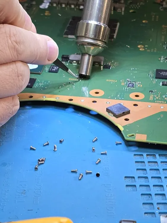 Carte mère de PS5 travaillée à l'air chaud, et processeur entouré de métal liquide